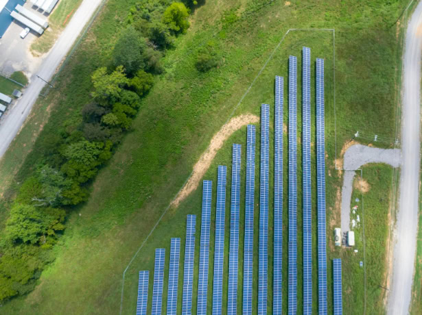 Aerial view of a solar panel array on commercial land, generating clean energy to support Net Zero goals.
